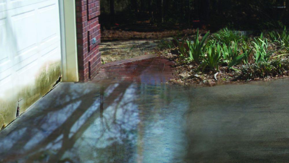 Driveway near garage door with flooding